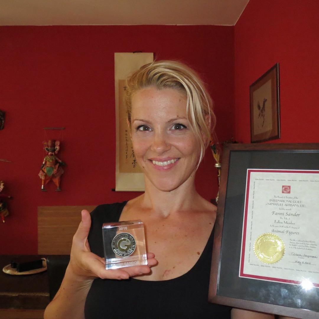 Fanni Sandor holds her Fellow award, standing in her studio.